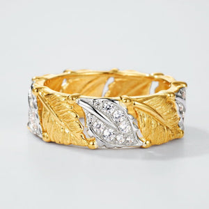 Gold and silver leaf-shaped bracelet on a light gray background