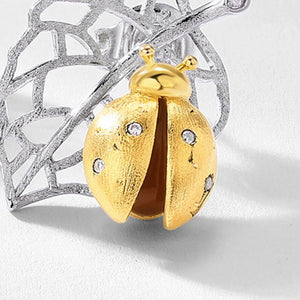 Gold ladybug pendant with silver lace background