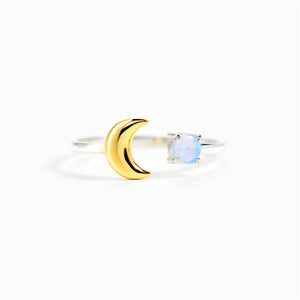 Gold ring with a moon design and opal stone on a white background
