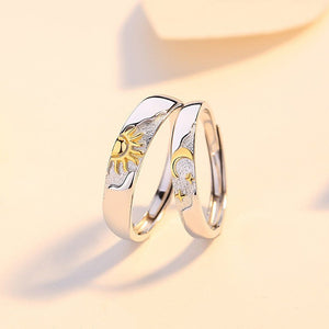 Two silver rings with gold sun and moon accents on a light beige background