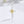 Silver cross pendant with a yellow flower design on a white background