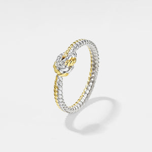 Two-tone ring with gold and silver design on a light gray background