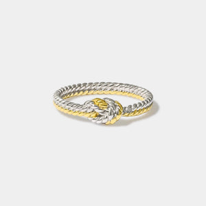 Two-tone ring with a knot design on a light gray background