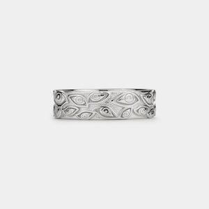 Silver ring with evil eye patterns on a white background