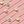 Gold necklaces with shell-shaped pendants on a pink background