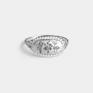 Silver ring with floral engraving on a light gray background
