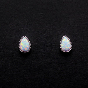 A set of vintage teardrop cut opal stud earrings with one pair showcasing a silver setting and another with a gold plating, displayed on a dark background.