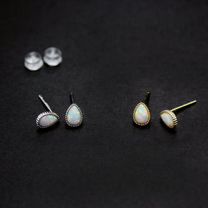 Pair of opal teardrop earrings on a black background