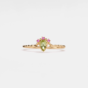 Gold ring with a green and pink gemstones on a white background