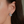Silver hoop earring worn by a person with dark hair.