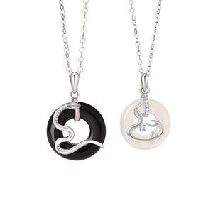 Two silver necklaces with black and white pendants on a white background