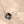 Two silver necklaces with circular pendants on a beige background