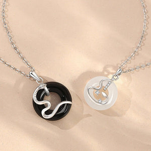 Two silver necklaces with circular pendants on a beige background
