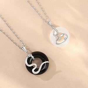 Two silver necklaces with circular pendants on a beige background