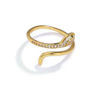 A gold-colored bypass ring with a snake design, featuring cubic zirconia, displayed on a white background.