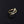 A gold-colored bypass ring with a snake design, featuring cubic zirconia, displayed on a black background.