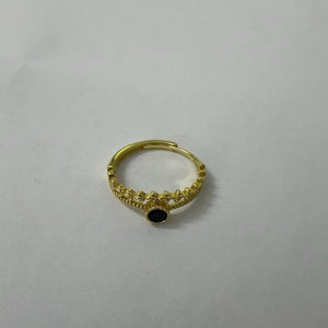 Gold ring with a black gemstone on a gray background