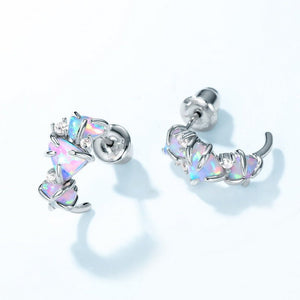 Silver earrings with colorful gemstones on a light gray background