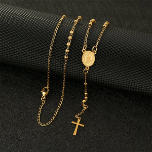 A collection of Virgin Mary cross drop Y necklaces with varying lengths, displayed on a white stand. The necklaces feature gold and silver colors with cross pendants and beaded chains.