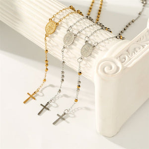 Three necklaces with different designs on a decorative white surface