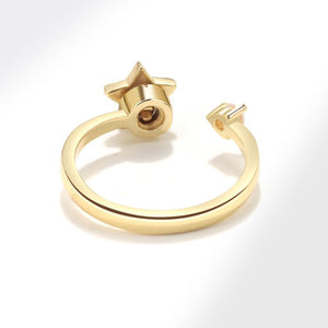 Gold spinner ring with star design and diamond on a white background