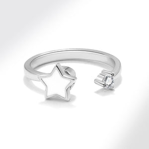 Silver spinner ring with star design and diamond on a white background