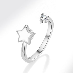 Silver spinner ring with star design and diamond on a white background