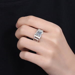 Hand wearing a silver ring with gemstones on a black background