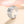 Silver ring with a diamond on a soft pink background