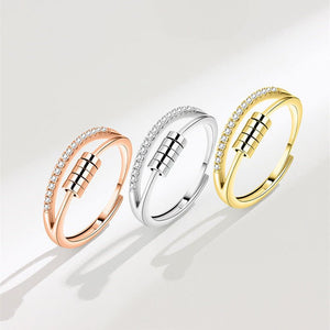 Three gold and silver rings with diamond accents on a light background