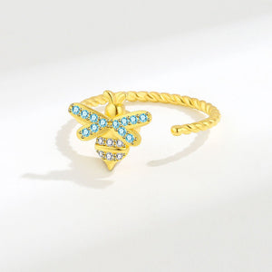 Gold ring with blue gemstones on a white background