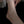 Silver anklet on a person's ankle against a dark background