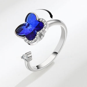Silver ring with a blue butterfly-shaped gem on a white background