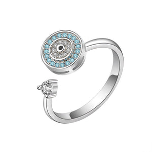 Silver evil eye spinner ring with blue gemstones and a diamond on a white background