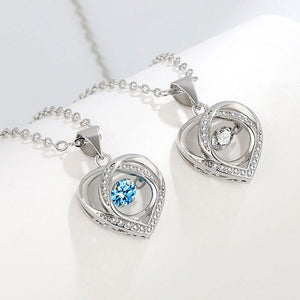 Heart-shaped silver pendants with blue gemstones on a white background