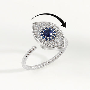 A silver ring with a large blue and clear cubic zirconia evil eye-shaped inset, designed as a fidget spinner.