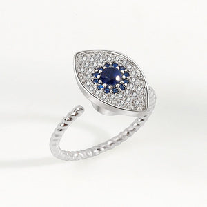 A silver ring with a large blue and clear cubic zirconia evil eye-shaped inset, designed as a fidget spinner.