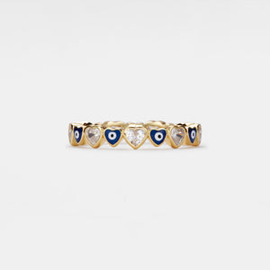 Gold ring with heart-shaped evil eye and gemstones on a white background