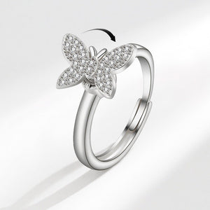 A silver-colored butterfly-shaped fidget spinner ring with cubic zirconia embedded in its design, displayed against a white background.