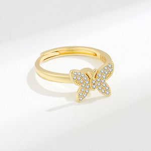 Gold butterfly ring with diamond accents on a white background