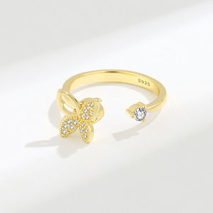 Gold ring with butterfly design and diamond on a white background