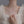 Silver necklace with floral pendant on a mannequin wearing a white dress.