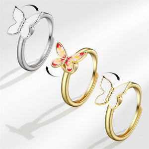 Three butterfly-shaped rings in silver, gold, and multicolor on a white background