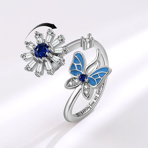 Silver ring with blue butterfly design and gemstones on a white background