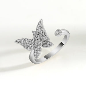 Silver spinner ring with diamond-encrusted butterfly design on a white background
