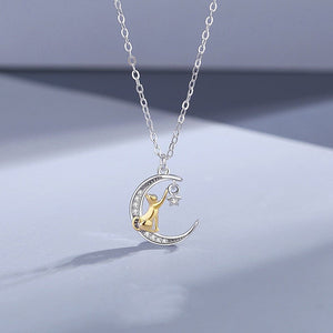 Silver necklace with a moon-shaped pendant featuring a gold figure on a light gray background