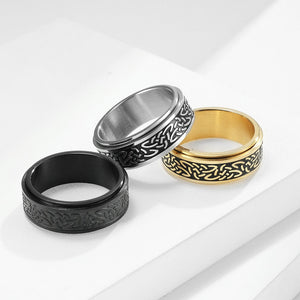Three rings in black, silver, and gold on a white background
