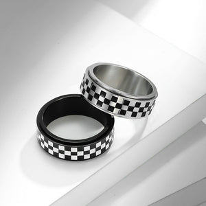 Two metallic rings with checkered pattern on a white surface