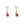Gold drop earrings featuring heart-shaped pink stones as studs with dangling teddy bear charms holding red gemstones, set against a white background.