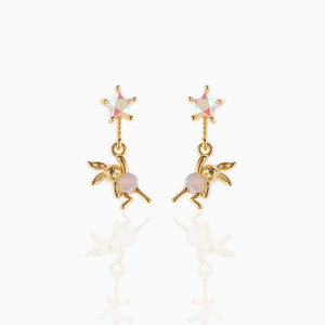 Gold drop earrings featuring star-shaped stud tops with iridescent stones and dangling bunny charms accented with soft pink beads, set against a white background.